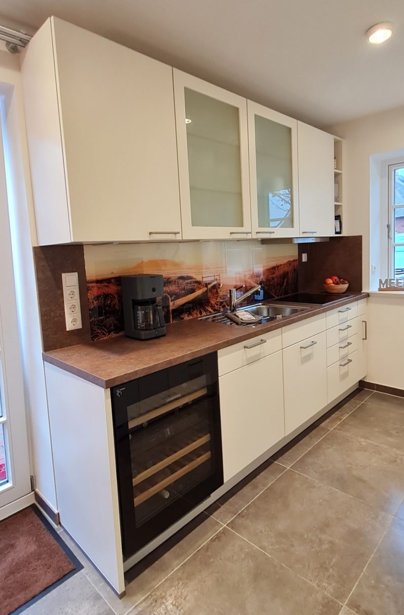 Moderne Küche mit Holzoberflächen und einem großen Fenster für Tageslicht